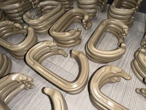 Several stacks of tan-colored plastic C-shaped objects are arranged on a light wood floor.